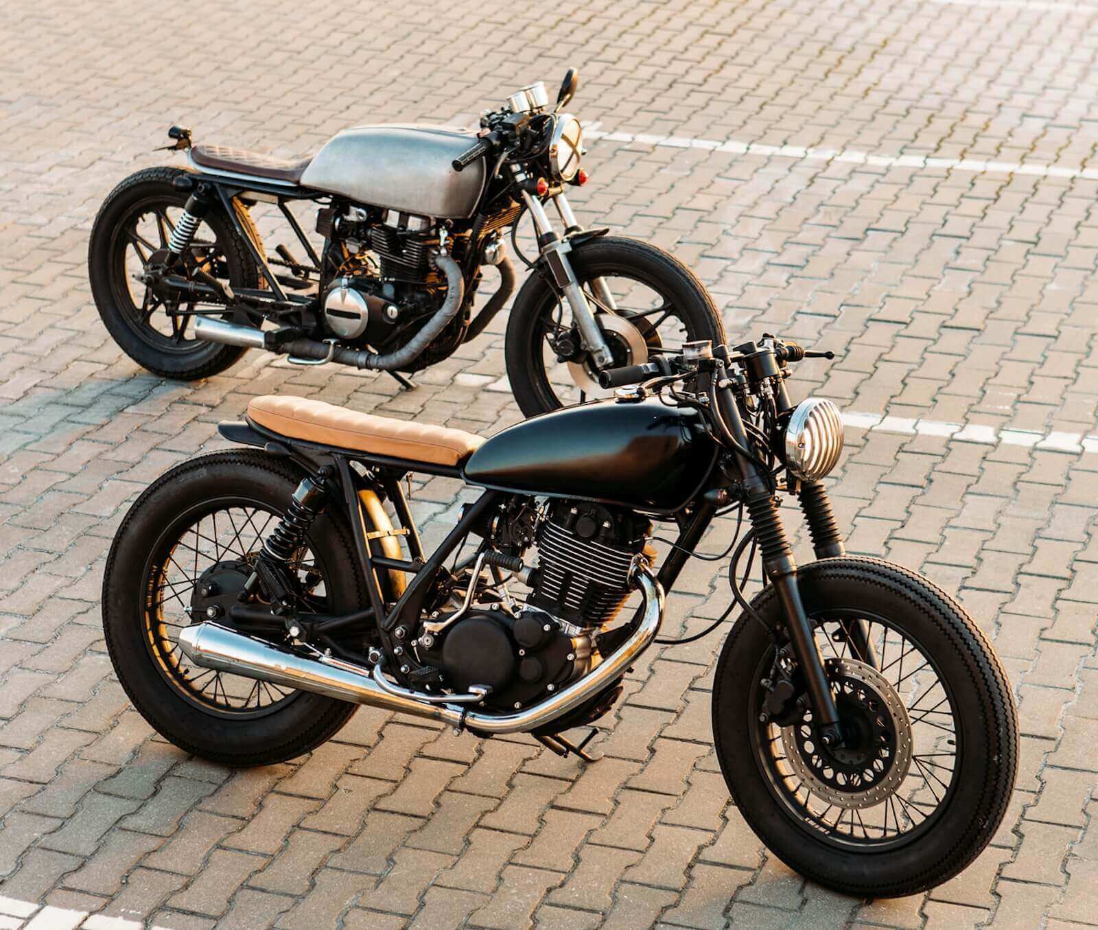 Two motorcycle riders parking together rather than splitting up. 