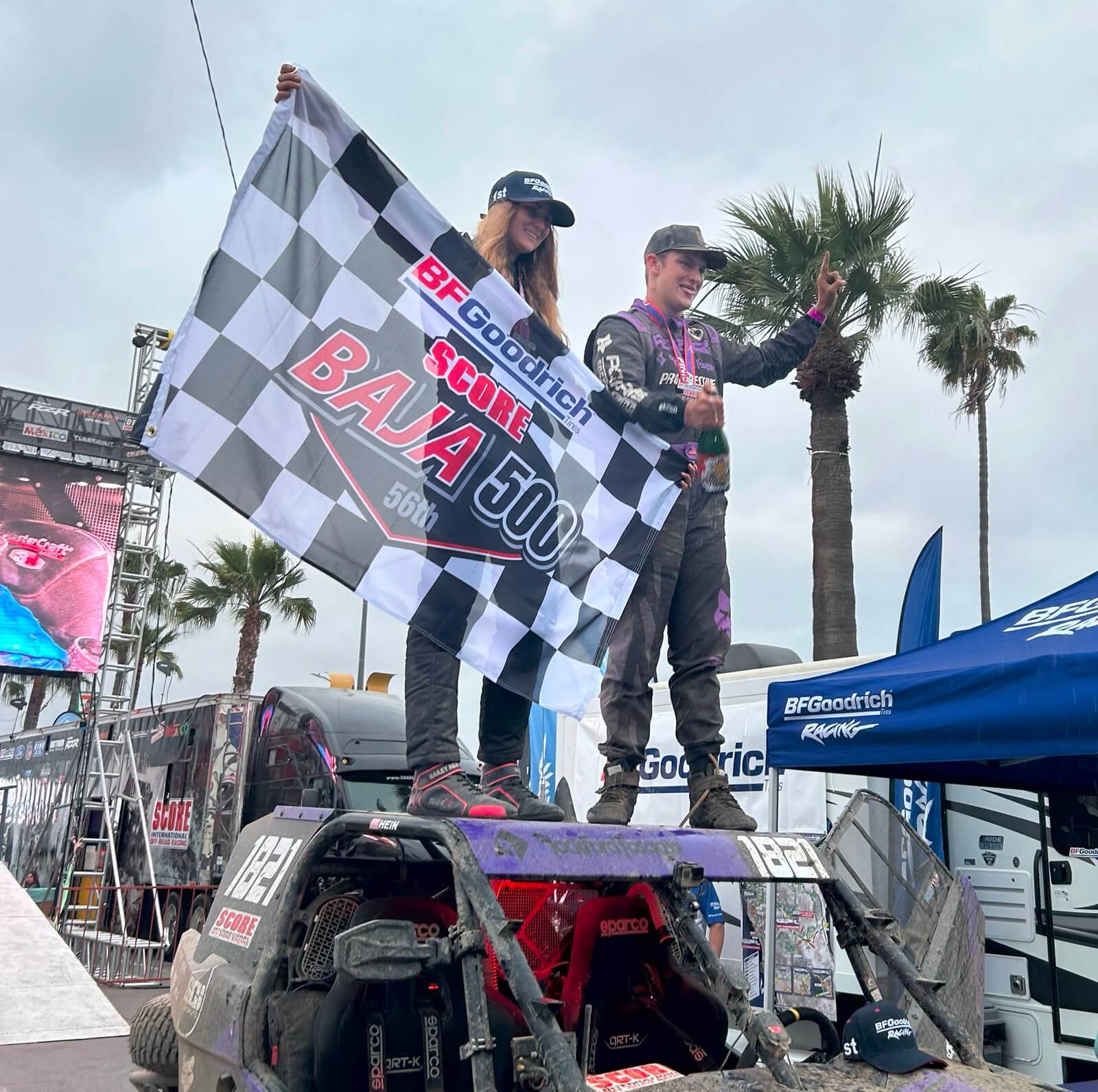 Cayden MacCachren celebrates a win at the SCORE Baja 500 alongside his partner. 
