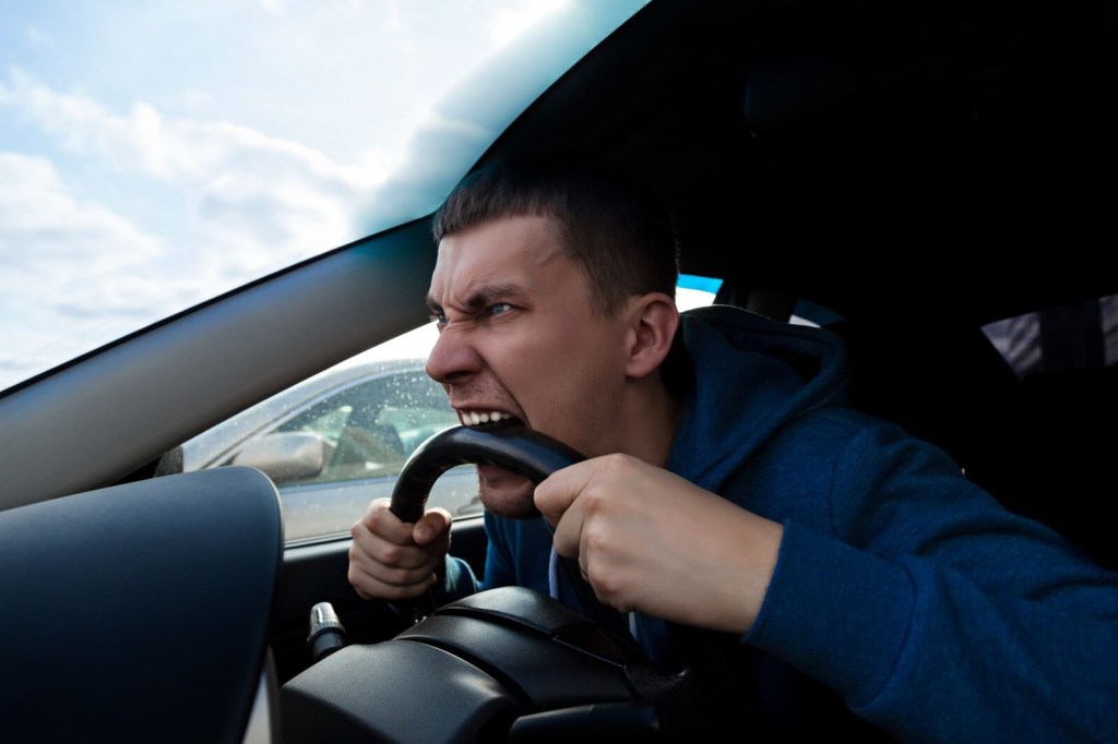 A driver gets a bad case of road rage and bites his steering wheel.