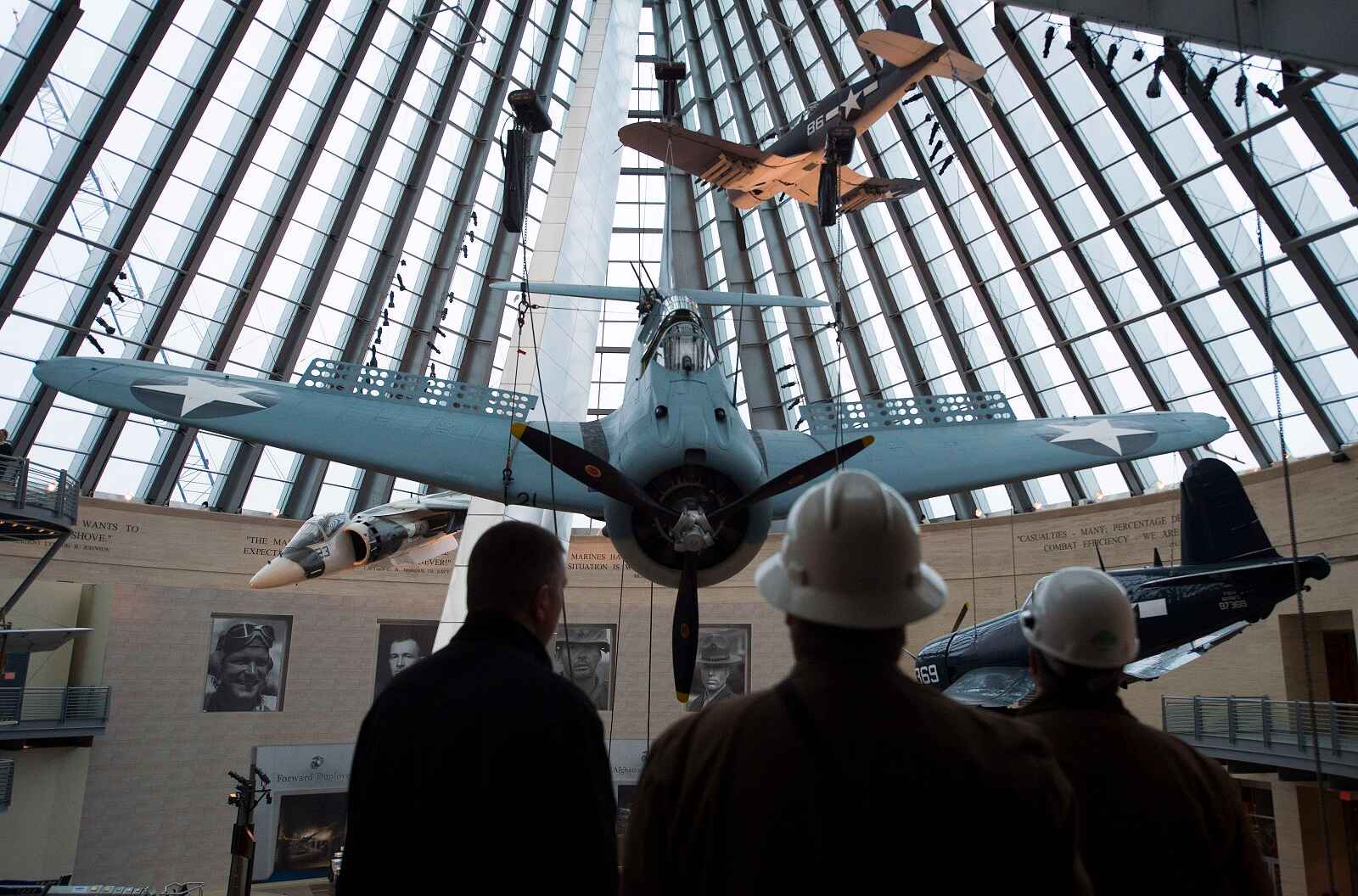 A blue restored SBD Dauntless dive bomber suspended in a museum