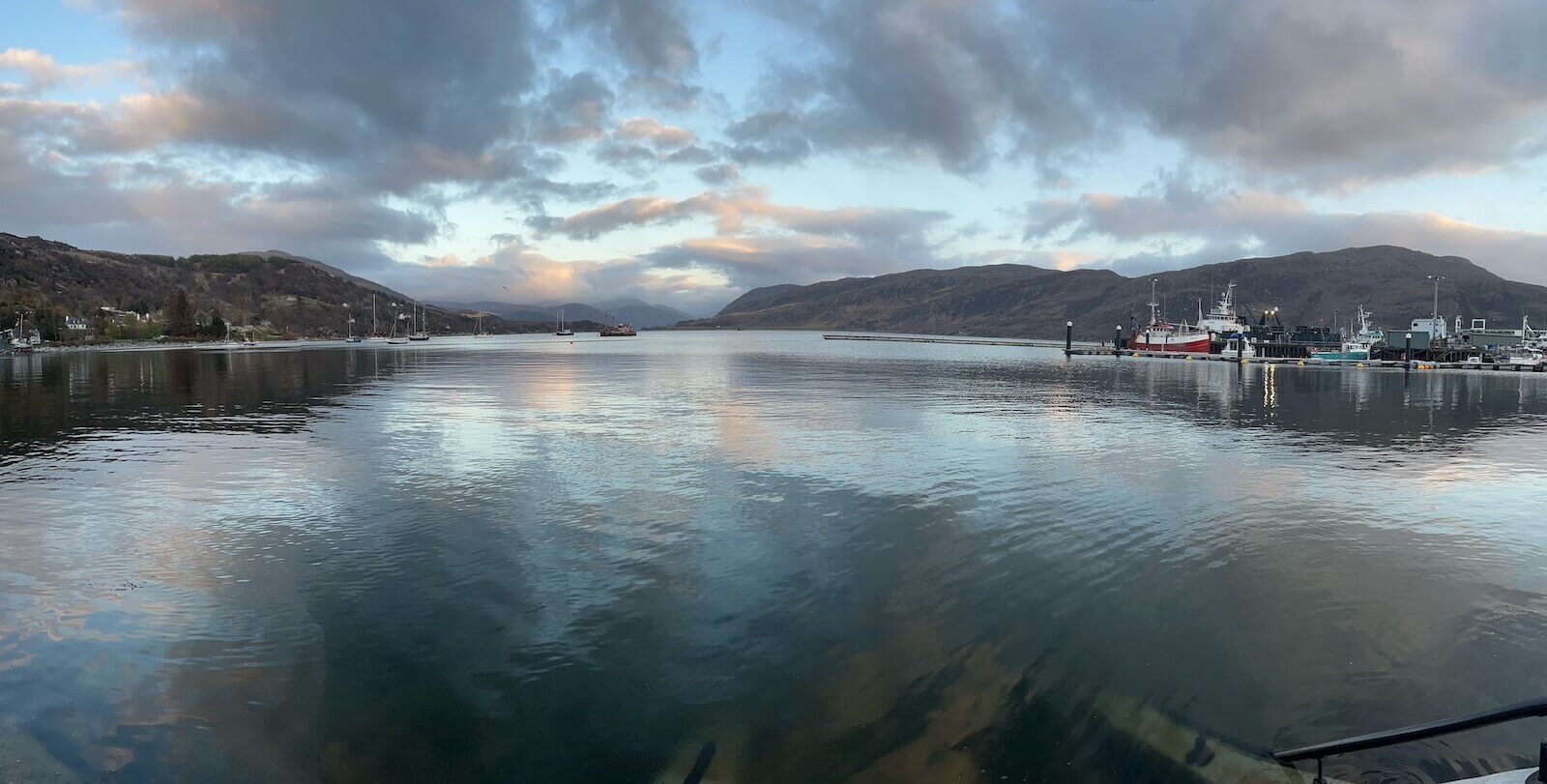 The harbor in Ullapool showcases glassy water on the shoulder of the NC 500.