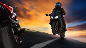 A sportbike rider does a wheelie.