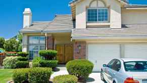 Home with two car garage and BMW parked in driveway, home upgrades can include a replacement garage door which has highest ROI