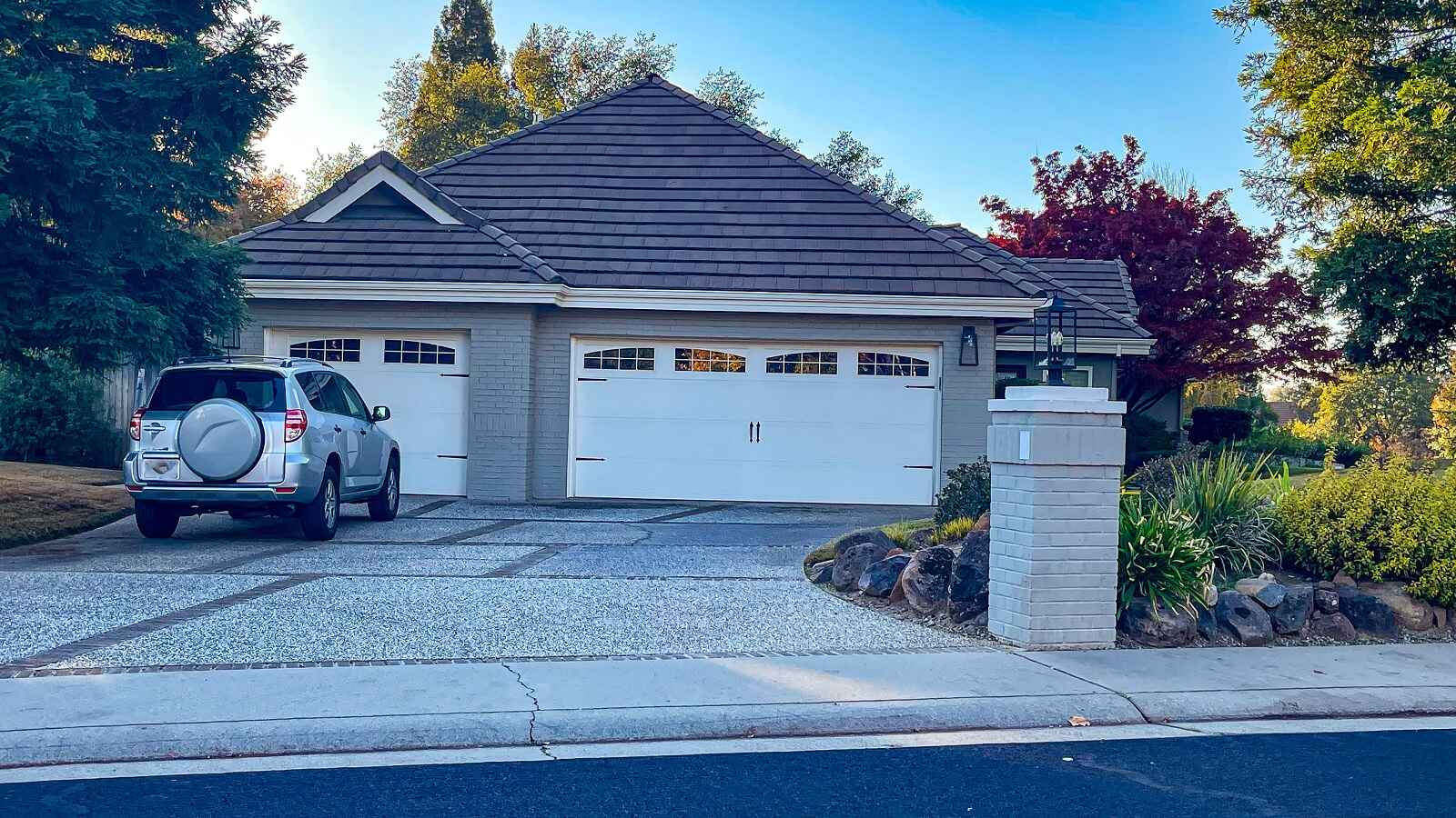 Home with three car garage and SUV parked in driveway