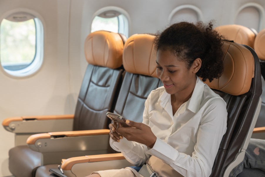A woman texting on her phone during a flight