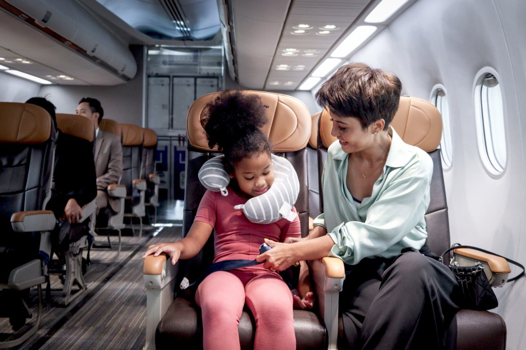 A mother and daughter sitting on an airplane