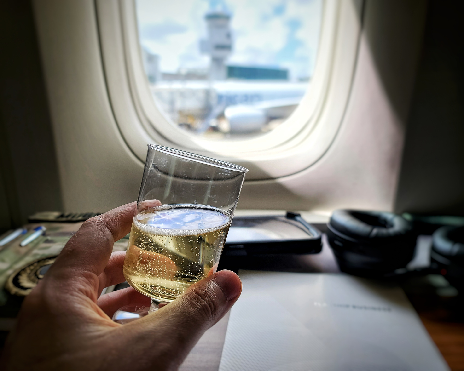Someone holding alcohol on a plane 