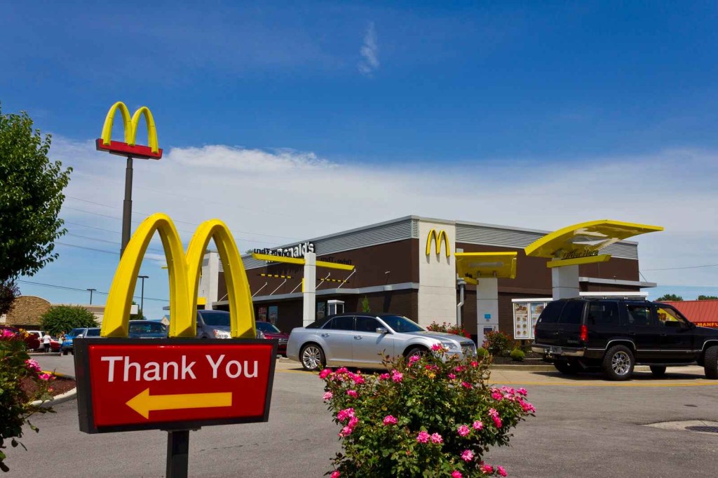 A McDonald's restaurant exterior with cars in drive-thru lane