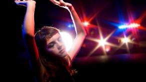 A woman holds here hands up as police prepare to arrest her for a DUI.