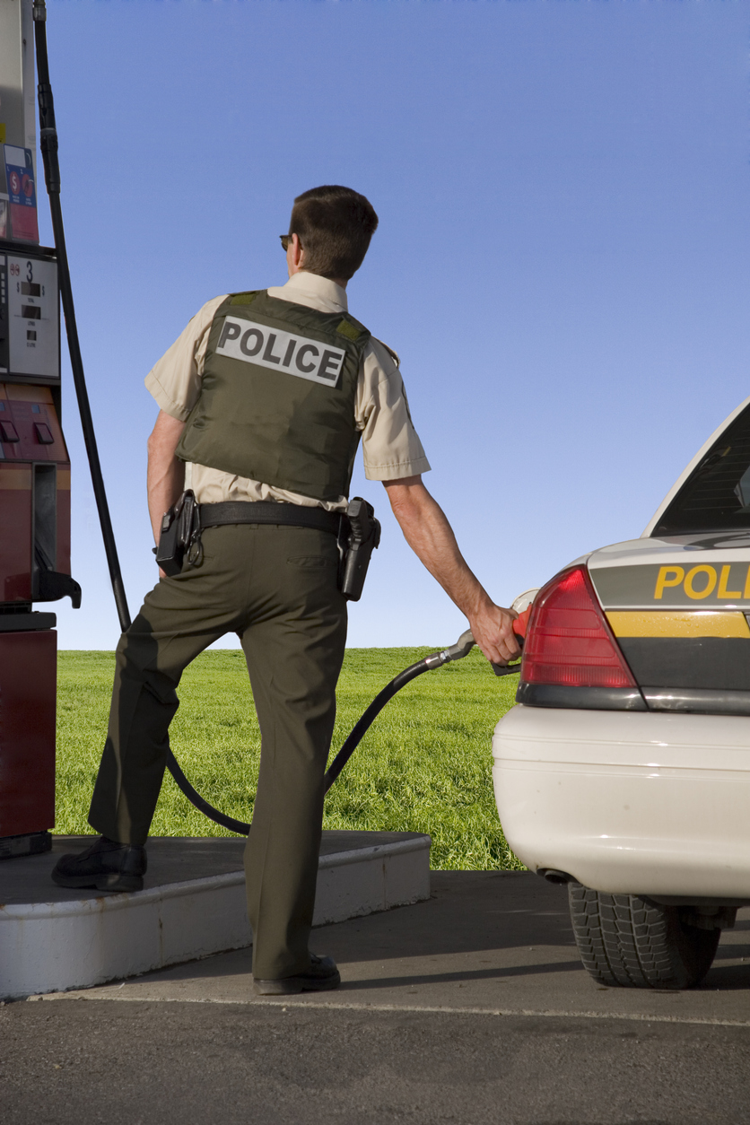 A police officer getting gas
