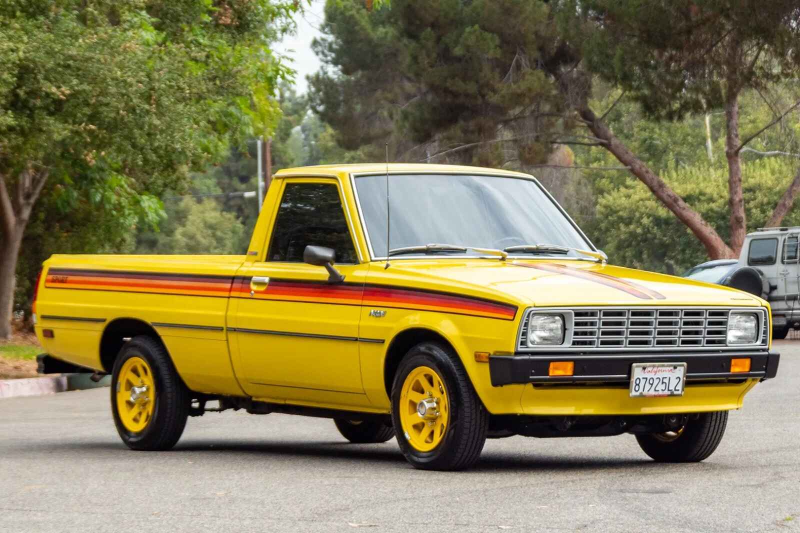 A yellow 1980 Plymouth Arrow vintage compact truck