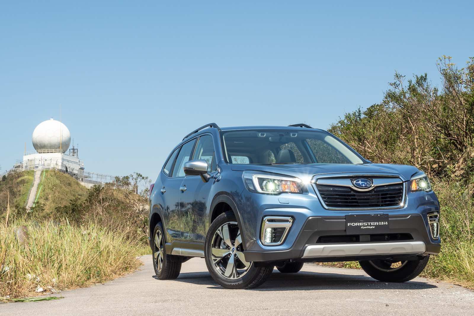 Blue 2018 Subaru Forester parked on a sandy trail.