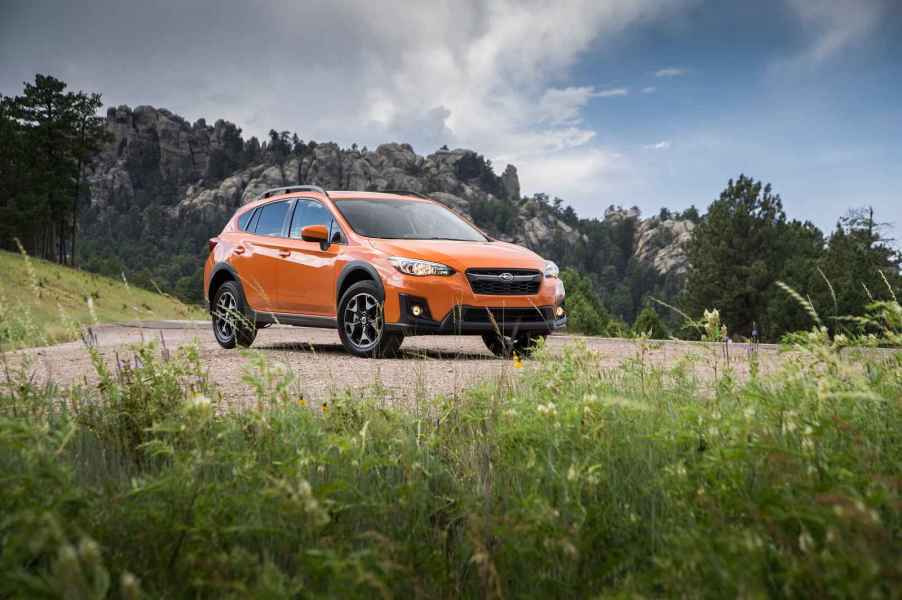An orange 2020 Subaru Crosstrek parked in a National Park-like setting in right front angle view midground position