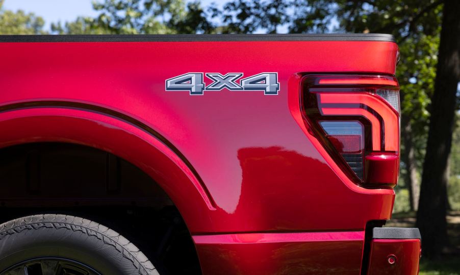 The 4x4 badge on the bed of a red Ford F-150 pickup truck.