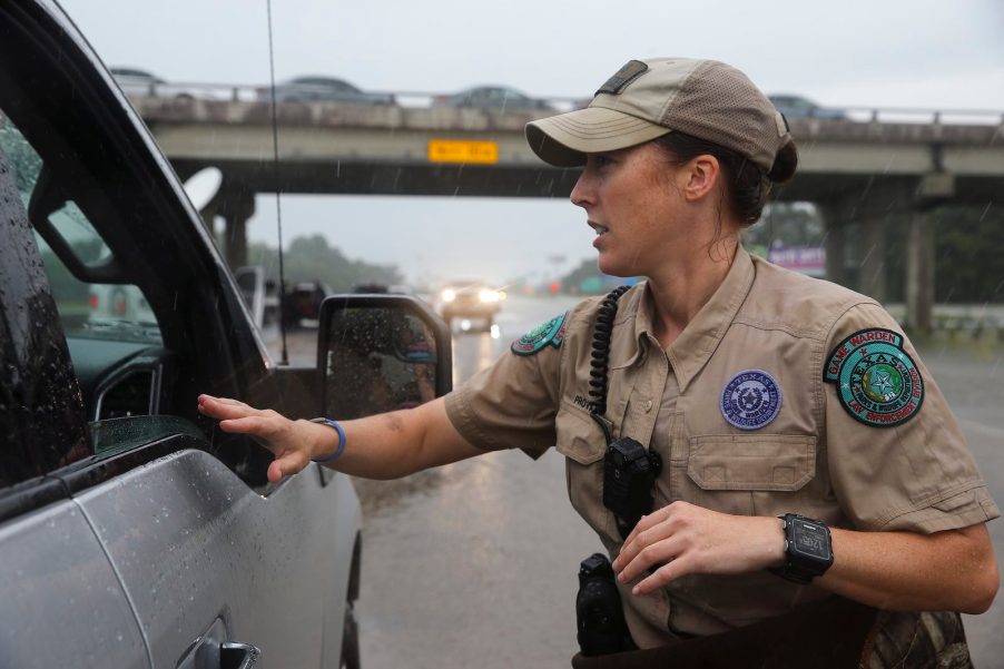 A Texas game warden talks to a driver of a pickup truck stopped on the highway.