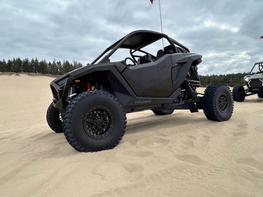 A new Polaris RZR Pro R in black on the beach after driving off-road.