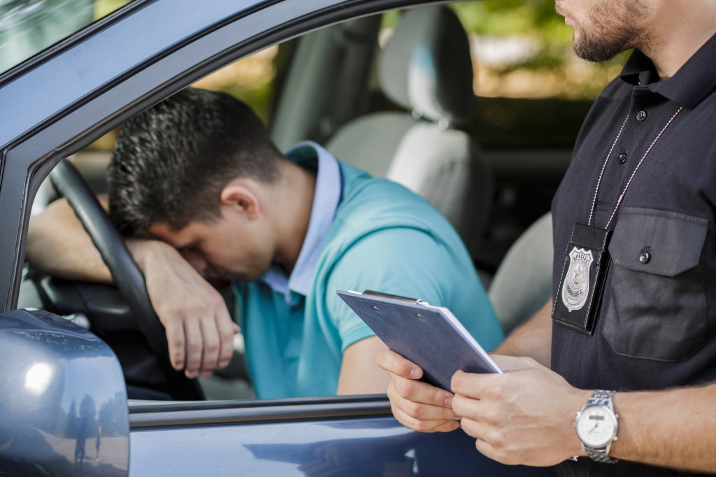 A cop issuing a ticket to a sad man