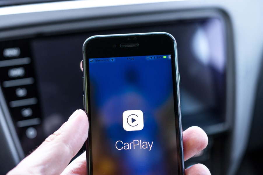 A man holding a phone while connecting Wireless Apple CarPlay