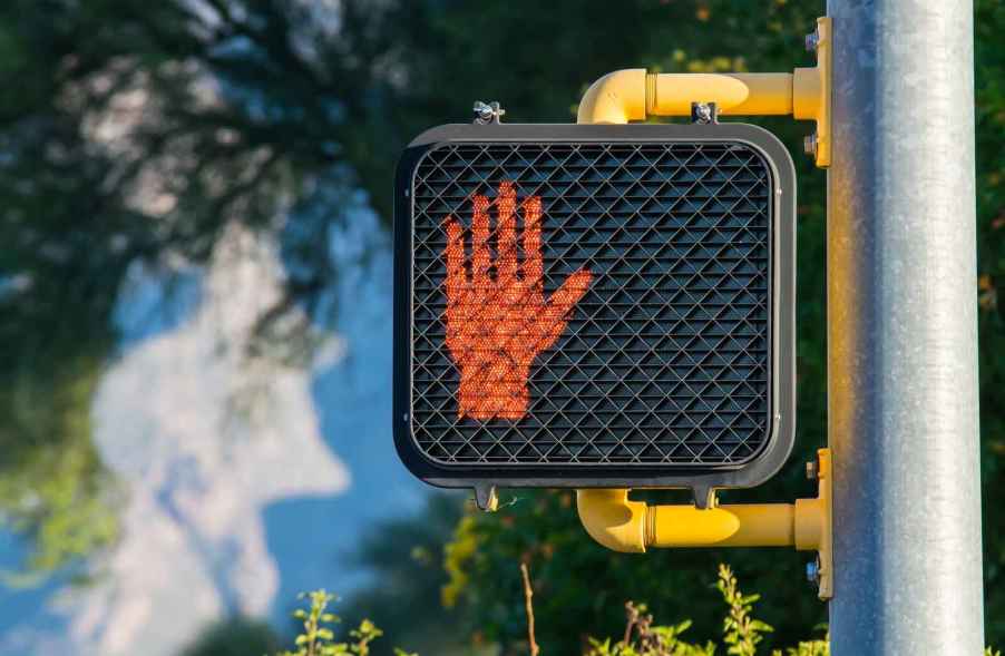 A red hand signal at a traffic light stops jaywalkers