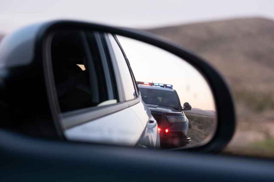 Police cruiser in car sideview mirror during a traffic stop