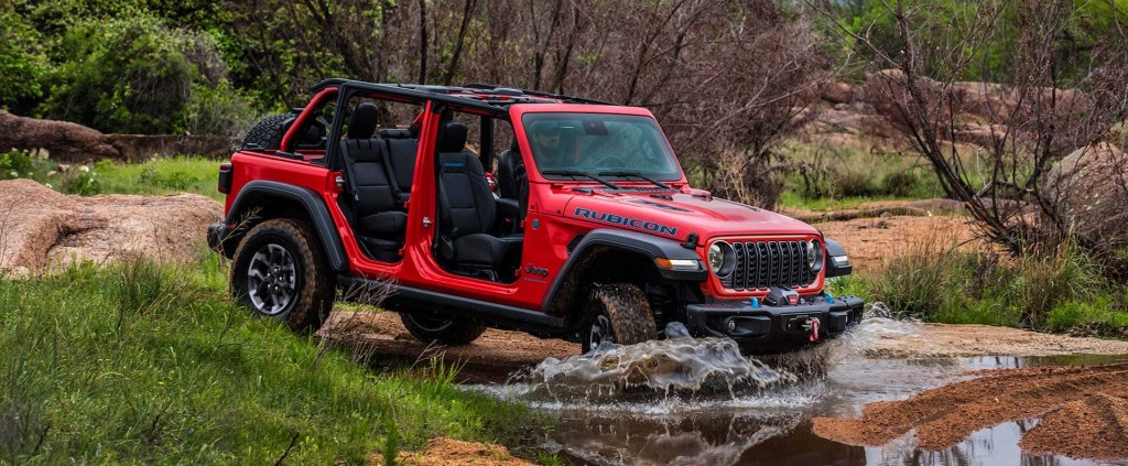 The 2025 Jeep Wrangler splashing through a stream