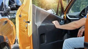 Pickup truck driver hangs foot out of cab to stop.
