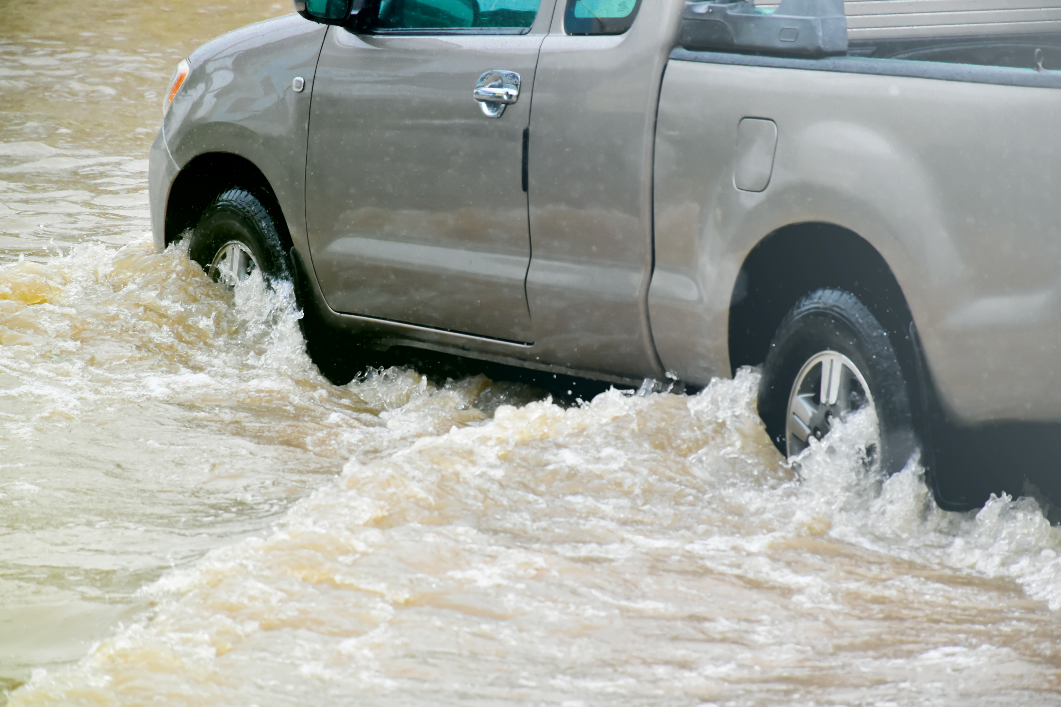 A truck driving through flood waters