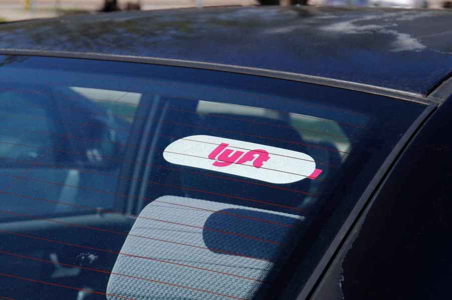 A Lyft rideshare sticker in a car's rear windshield in close view