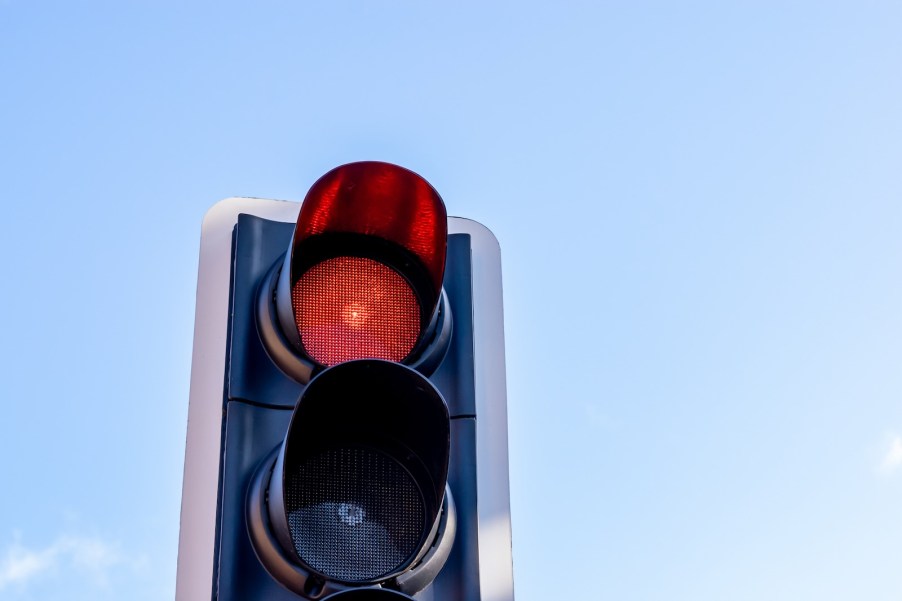 Red traffic light against the blue sky.