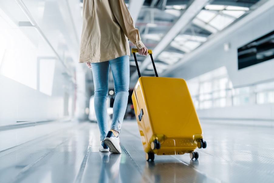 Airline passengers like this one with her rolling luggage are angry about rising costs and lost bags.