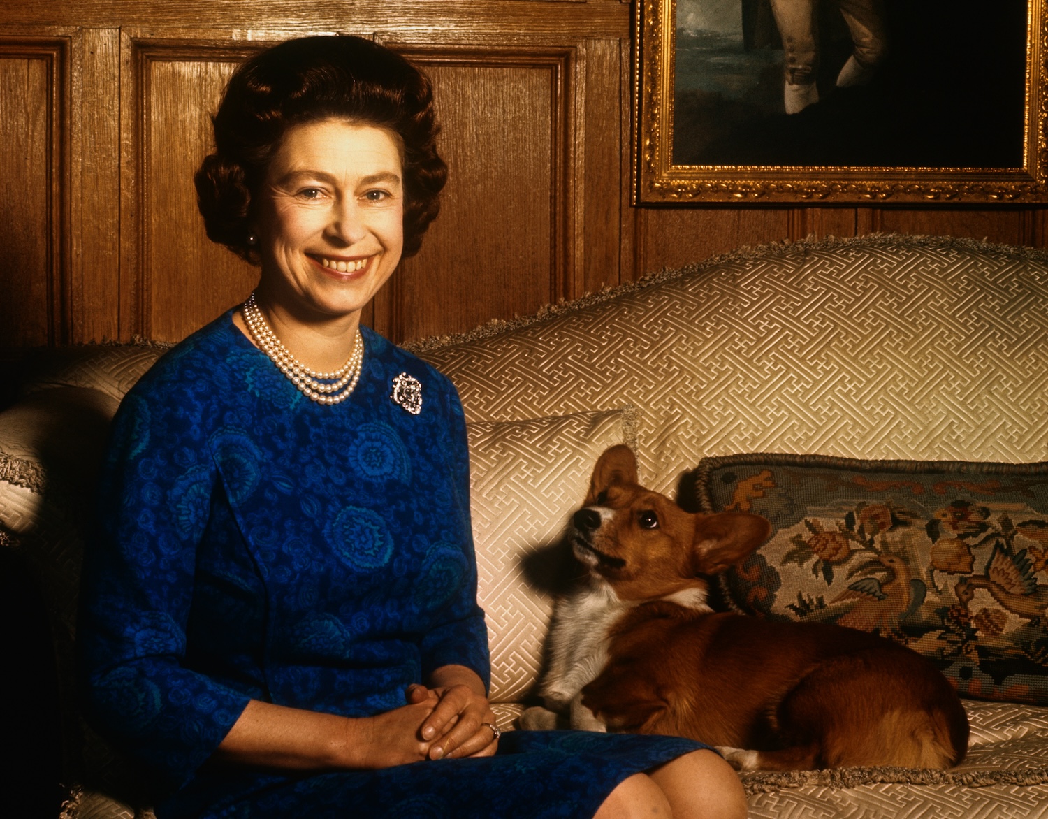 Queen Elizabeth II sitting with a corgi