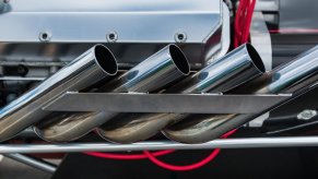 A set of open header exhaust pipes on a custom car build.