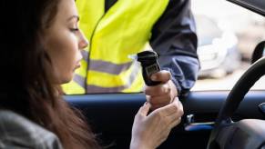 A driver uses an breathalyzer along with insurance following a DUI.