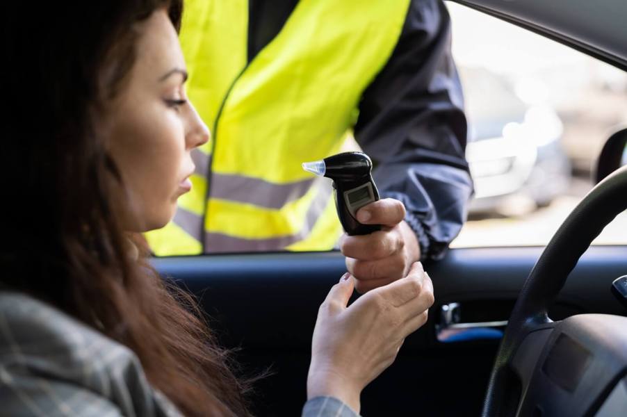 A driver uses an breathalyzer along with insurance following a DUI.