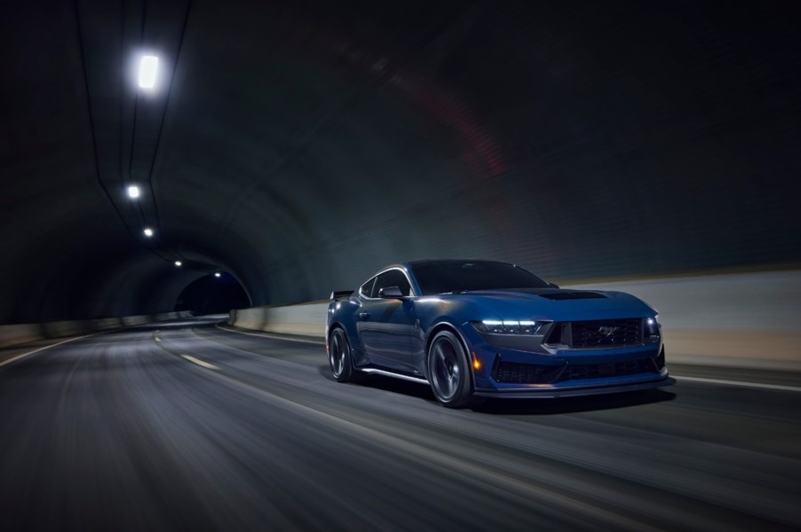 A Ford Mustang Dark Horse drives through a dark tunnel.