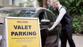 Valet parking attendant opening a driver's door.
