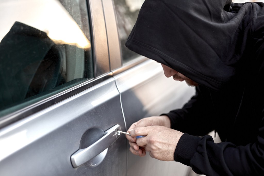A thief popping the lock on a car door
