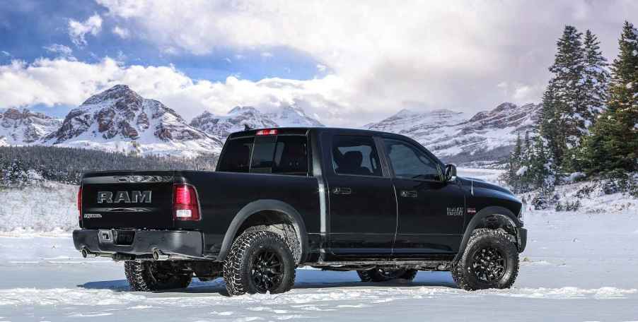 A black 2017 Ram 1500 pickup truck parked in a snowy mountainous landscape in full right profile view, this model year is arguably one of the best used pickup trucks on the market