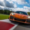 An orange Chevrolet Corvette Z06 takes on a track like the Nürburgring.