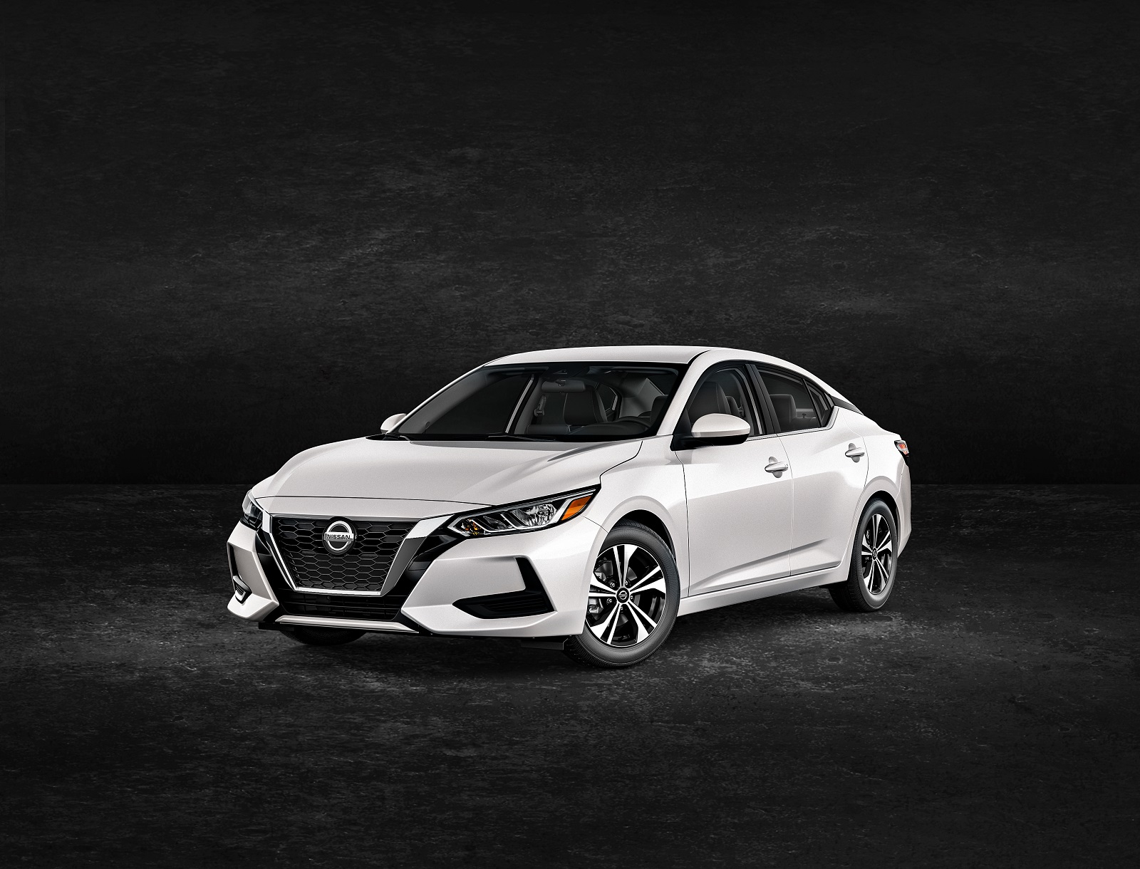A white 2023 Nissan Sentra four-door sedan parked in left front angle view with a black background
