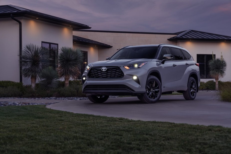 The grille of a 2025 Toyota Highlander Hybrid night edition crossover parked in a driveway.