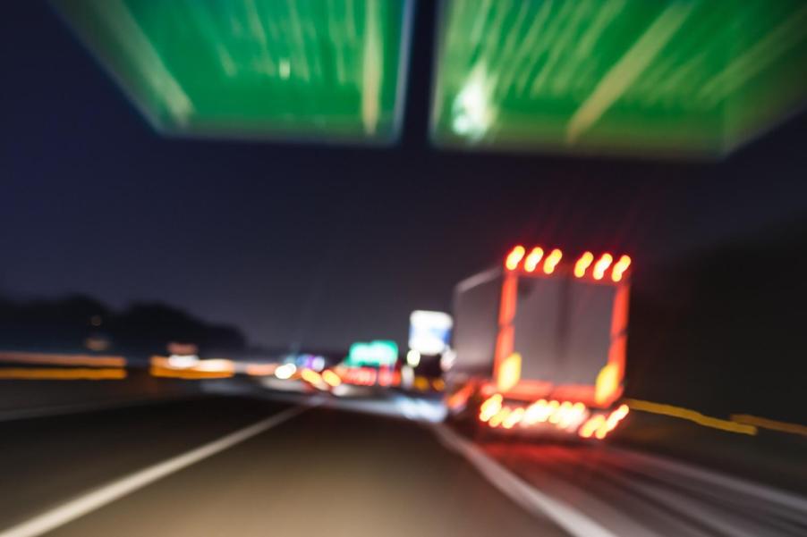 A blurred view of a semi-truck about to crash on a highway.