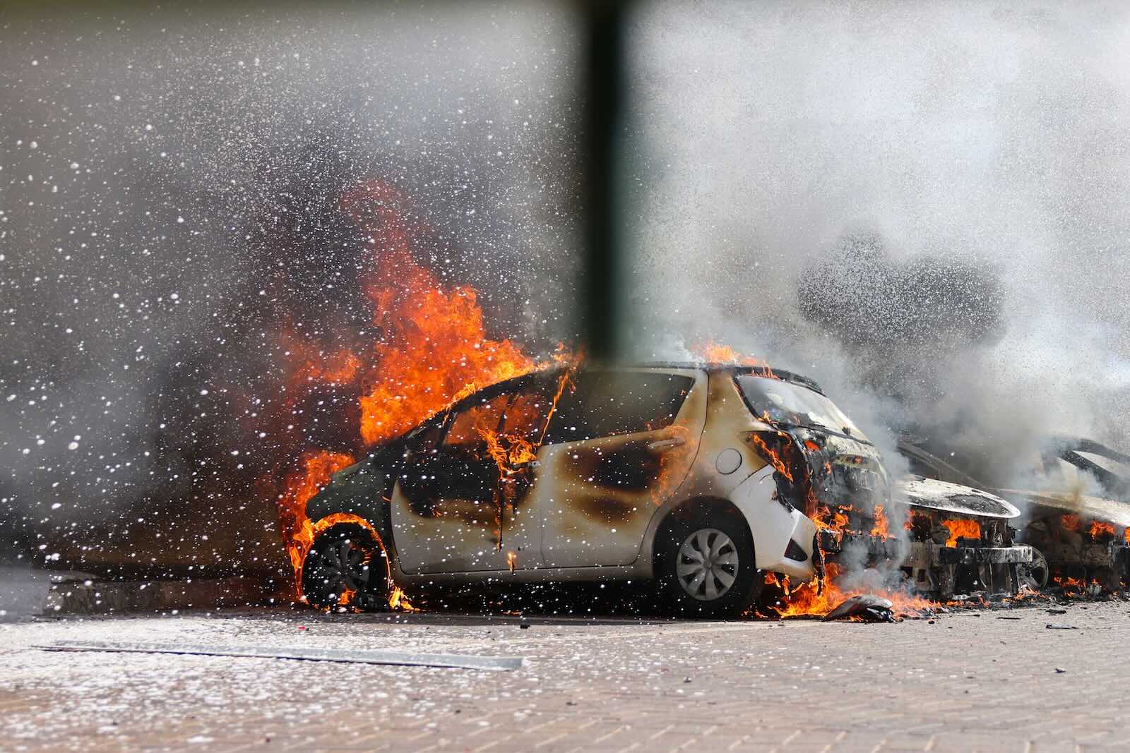 White compact crossover car surrounded by ashes.