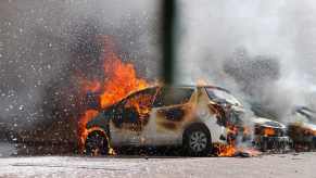 White compact crossover car surrounded by ashes.