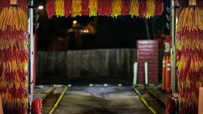 The bright red and yellow bristles of a car wash at night.