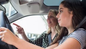 Driver's ed instructor pointing to order teenage driver to complete an errand