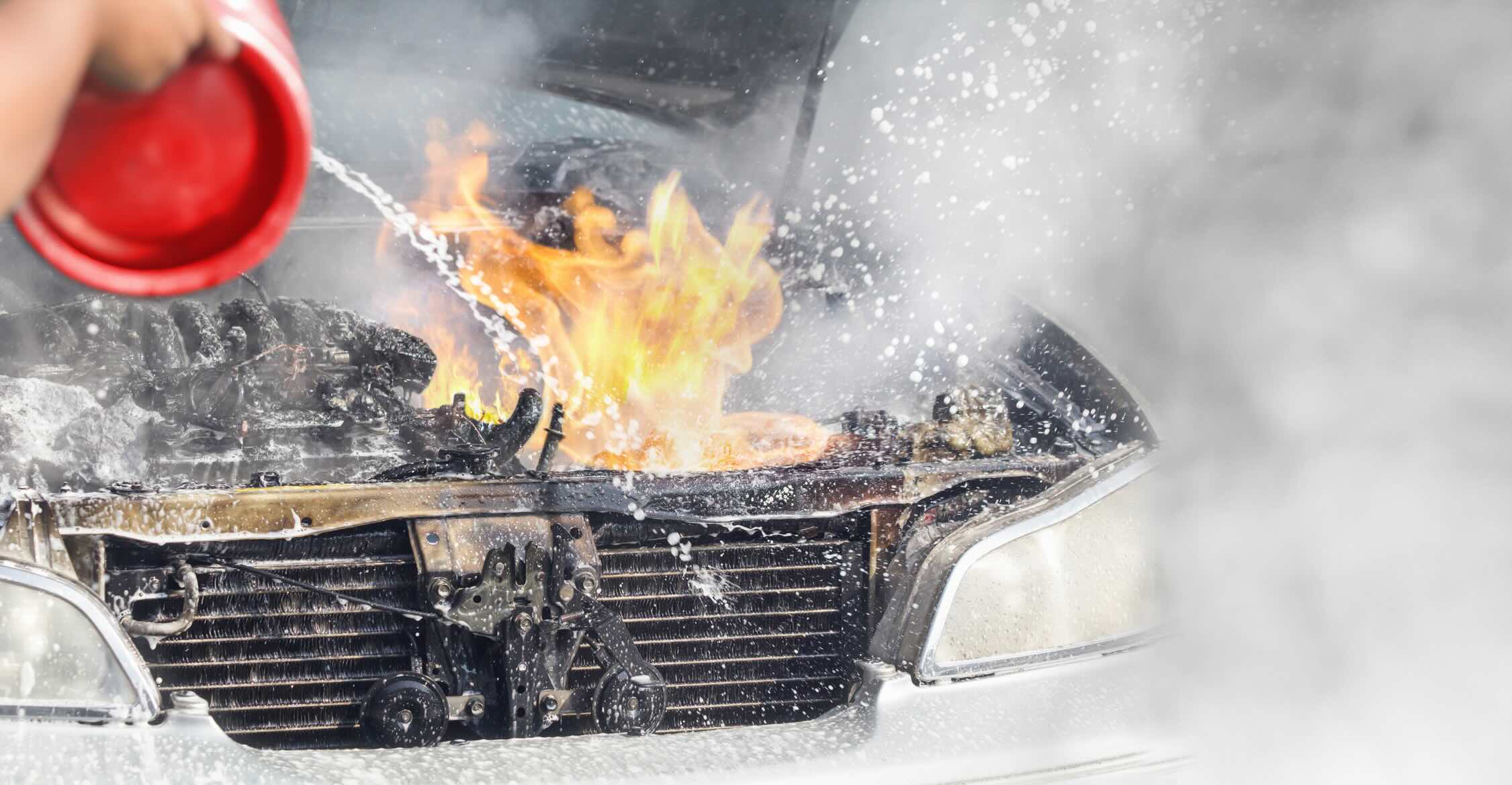 Engine Running On Fire Camper packs gear--propane fuel--into engine compartment of overloaded car