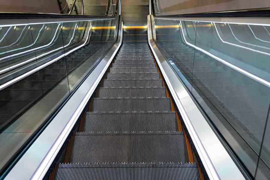 Looking down the metal steps of an escalator.