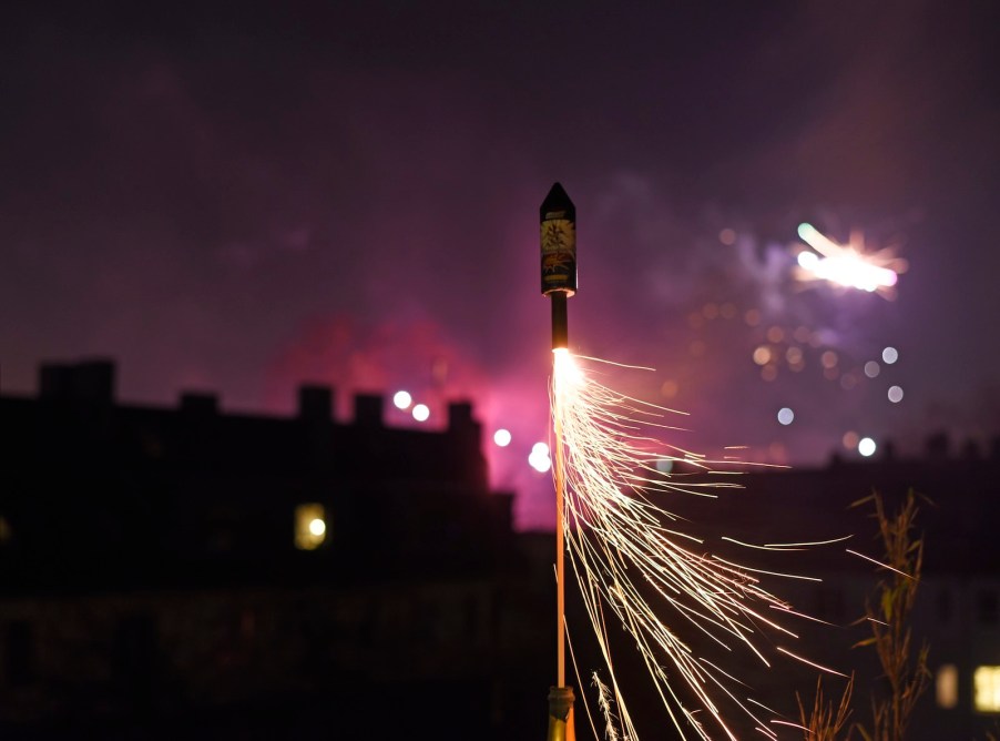 Fireworks rocket launching into a purple night sky