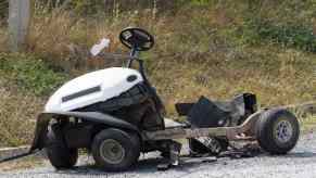 The wreckage of a crashed and bent golf cart.